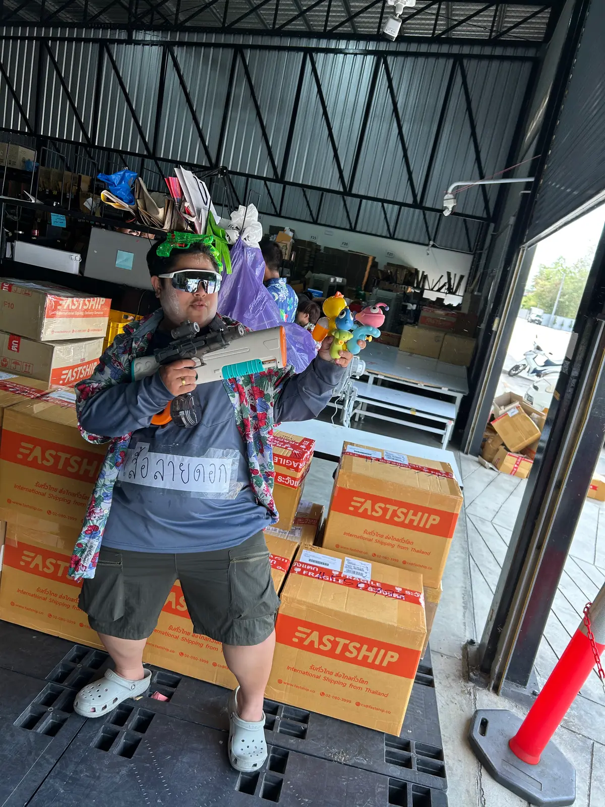 Posing with the water gun and a pile of toys in the warehouse