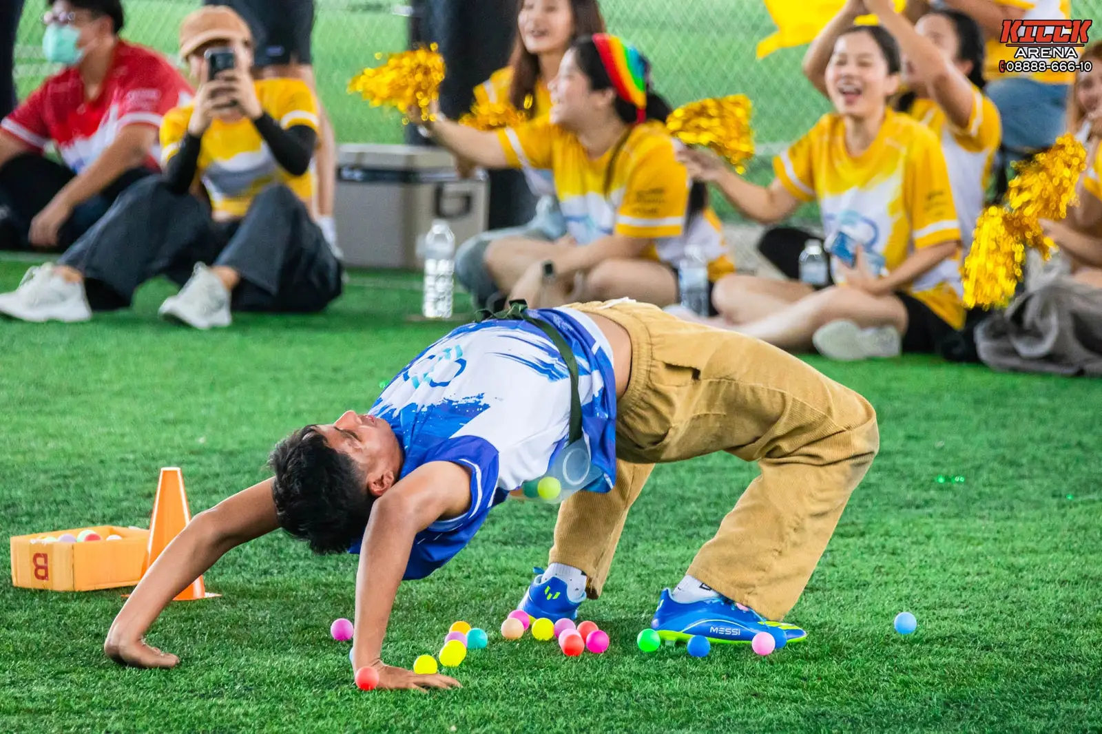 A player on all fours collecting balls while the yellow team cheers
